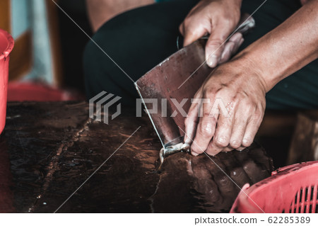Chinese person peeling skin off small fish Chinese person peeling skin off small fish 62285389