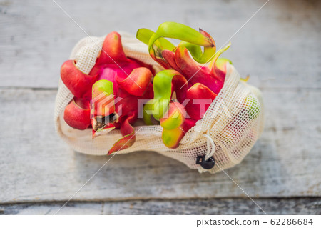 Dragon fruit in a reusable bag on a stylish wooden kitchen surface. Zero waste concept, plastic free 62286684