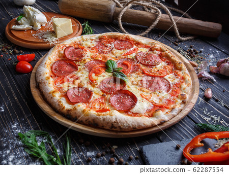 Aromatic pizza with sausage and tomatoes is 62287554