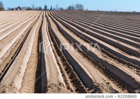 ploughed furrows in the ground, smooth the ruts of 62288660