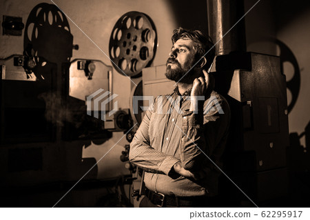 man standing near a film projector in the room man standing near a film projector in the room 62295917