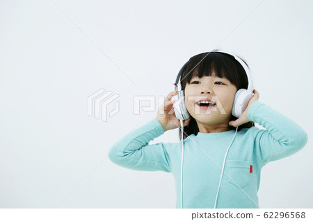 Girl listening to music with headphones white background 62296568