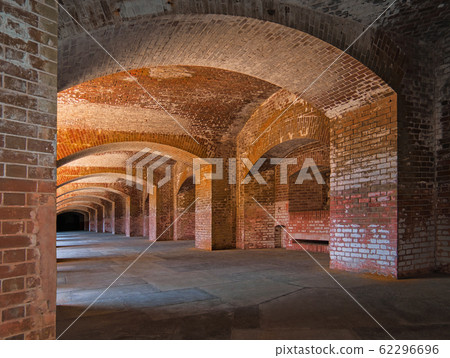 A long corridor with thick brick walls and arches A long corridor with thick brick walls and arches 62296696