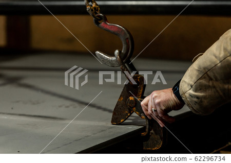 industry worker is working with hooks from crane .at a factory 62296734
