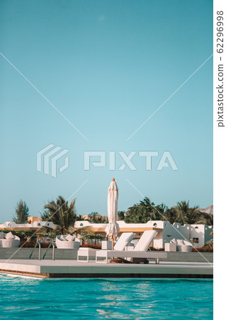 White lounge chairs on a beautiful tropical beach at Maldives 62296998