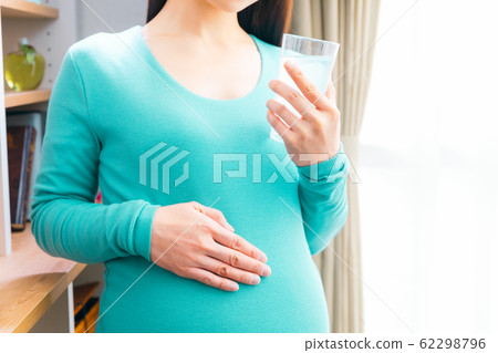 Pregnant woman drinking sports drink 62298796