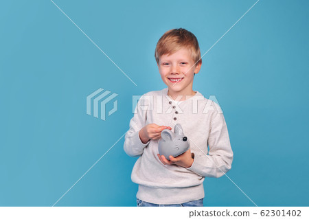 portrait of cute little boy putting money in moneybox 62301402