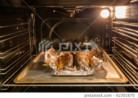 Baked mackerel fish on the pan inside gas oven Baked mackerel fish on the pan inside gas oven 62301670