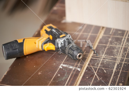 Drill with wooden board in workshop, close-up Drill with wooden board in workshop, close-up 62301924