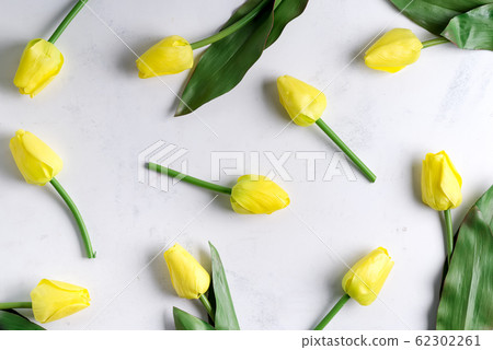 Floral pattern made of yellow tulip on marble background. Flat lay, top view. Holiday background. 62302261