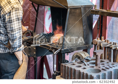 Male blacksmith working in workshop, London. Concept. 62302492