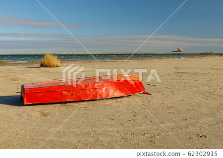 red boat lies on the lake 62302915