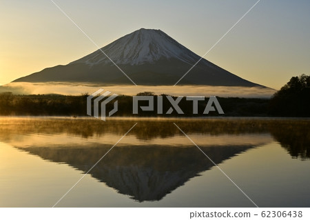 Fishing boat and upside down Fuji in Shoji Lake where morning fog stands 62306438