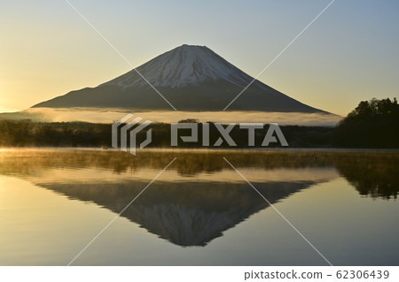Fishing boat and upside down Fuji in Shoji Lake where morning fog stands 62306439