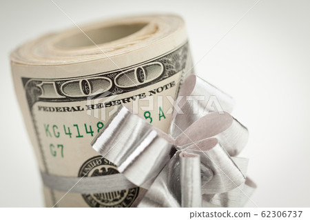 Roll of One Hundred Dollar Bills With Silver Bow Roll of One Hundred Dollar Bills With Silver Bow 62306737
