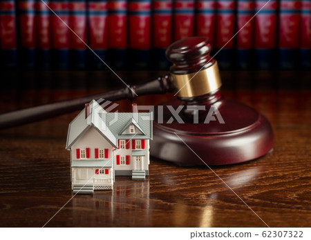 Gavel and Small Model House on Wooden Table. Gavel and Small Model House on Wooden Table. 62307322