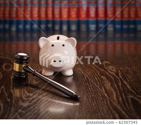 Gavel and Piggy Bank on Wooden Table With Law Books Behind Books Behind 62307345