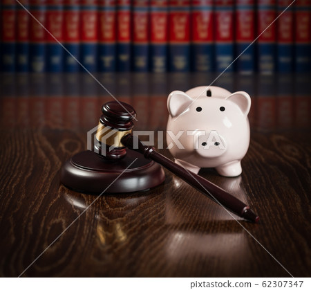Gavel and Piggy Bank on Wooden Table With Law Books Behind Books Behind Gavel and Piggy Bank on Wooden Table With Law Books Behind Books Behind 62307347