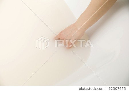 一個年輕的女人，看著浴溫的手 62307653