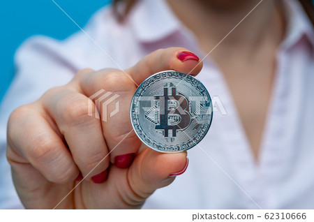 Young unidentified woman holding a bitcoin coin 62310666