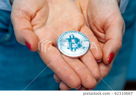 An unidentified young woman holds a bitcoin An unidentified young woman holds a bitcoin 62310667