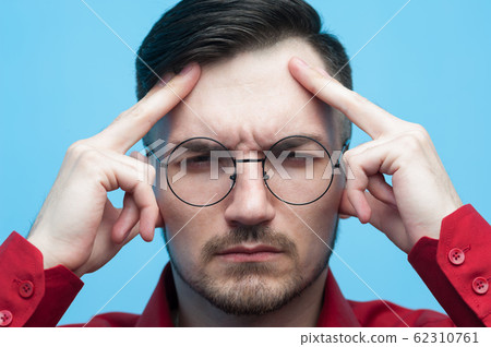 Close-up portrait of a serious man suffering his head 62310761