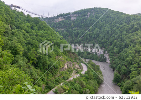 A gorge in the mountains with a suspension bridge A gorge in the mountains with a suspension bridge 62312912