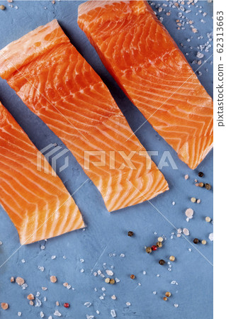 Raw salmon, top shot with salt and pepper. Cooking fish, a flatlay Raw salmon, top shot with salt and pepper. Cooking fish, a flatlay 62313663