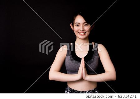 Young woman (fitness, black background, sportswear, gassho) 62314271