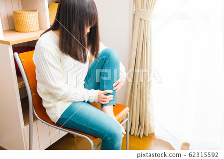 A woman who massages a calf massage swelling and squatting 62315592