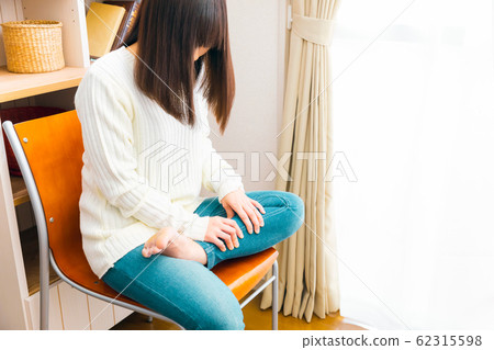 A woman who massages a calf massage swelling and squatting 62315598