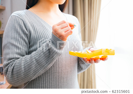 Woman using medicine case Woman using medicine case 62315601