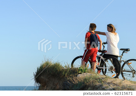 boy and young woman on a Bicycle on a cliff by the 62315671