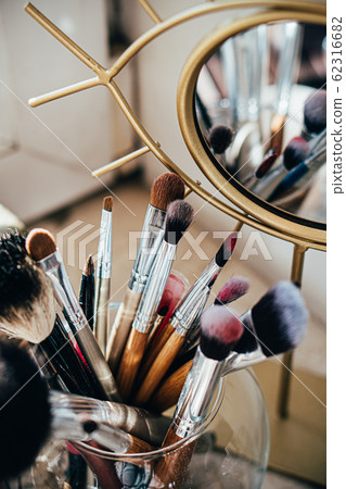 Many different makeup brushes in artist's studio with mirror reflection Many different makeup brushes in artist's studio with mirror reflection 62316682