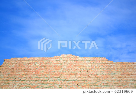 blue sky and brick wall wall of red brick shattered against the blue sky 62319669