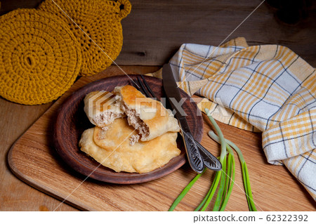 Clay plate of fried meat pies with cutlery and 62322392