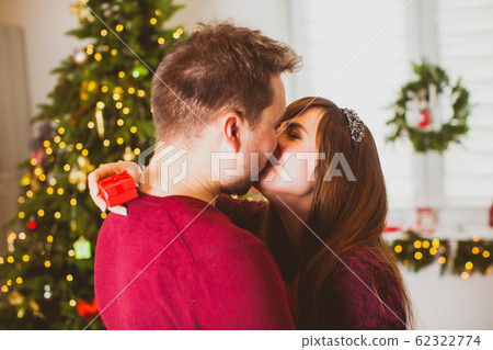 Portrait of kissing couple at home while Christmas 62322774