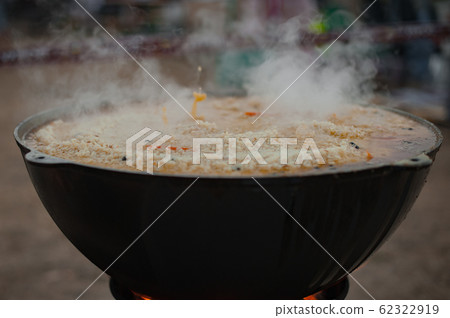 Cauldron with pilaf. Pilaf boils in a cauldron. Street food 62322919