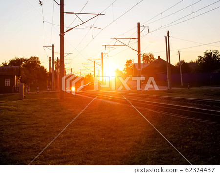 Railroad crossing on which cars ride in the background of the sun. Rail accident concept involving road transport, copy space 62324437