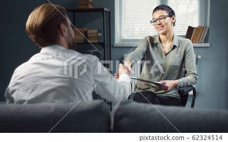 Thankful client shaking psychologist's hand Thankful client shaking psychologist's hand 62324514