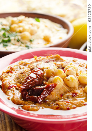 Fresh homemade Hummus in clay dish topped with 62325720