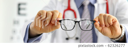 Male medicine doctor hands giving pair of black glasses 62326277