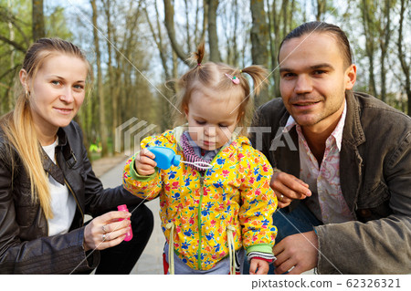 Happy parents with daughter outdoor 62326321