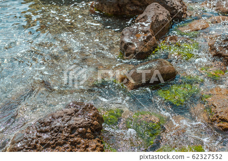 Pure clear water on a wild stone beach in the sea 62327552