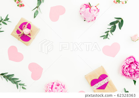 Frame of peonies, roses flowers and eucalyptus with gifts on white background. Flat lay, top view 62328363