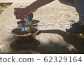Woman's hands putting dog's food into the bowls 62329164