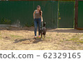 Woman volunteer walking with a dog 62329165
