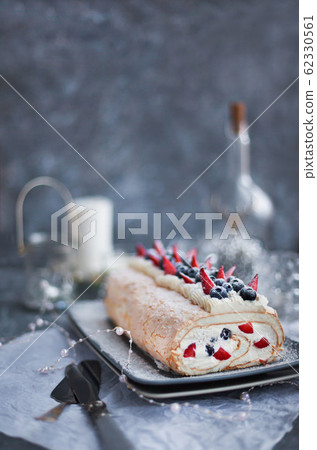 Meringue roll cake with cream and fresh berries Meringue roll cake with cream and fresh berries 62330561