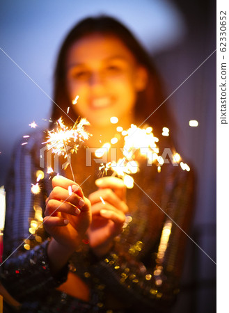 Delighted young lady smiling and waving burning Delighted young lady smiling and waving burning 62330652