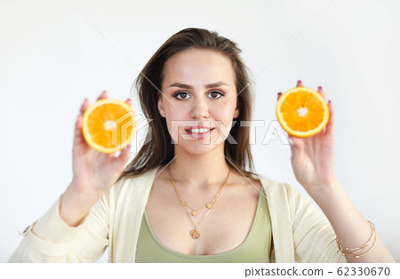 Young girl holding ripe orange isolated on light Young girl holding ripe orange isolated on light 62330670
